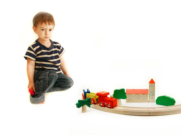 Criança brincando com trem de madeira — Fotografia de Stock