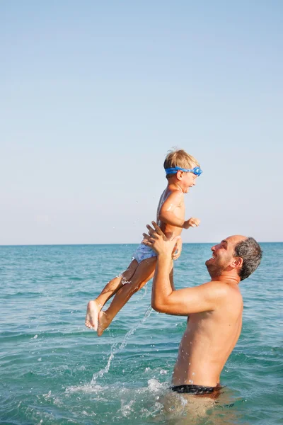 Father and son playing on water — Stok fotoğraf