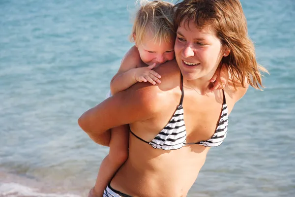 Boldog anya és a gyerek a háttérben tenger — Stock Fotó