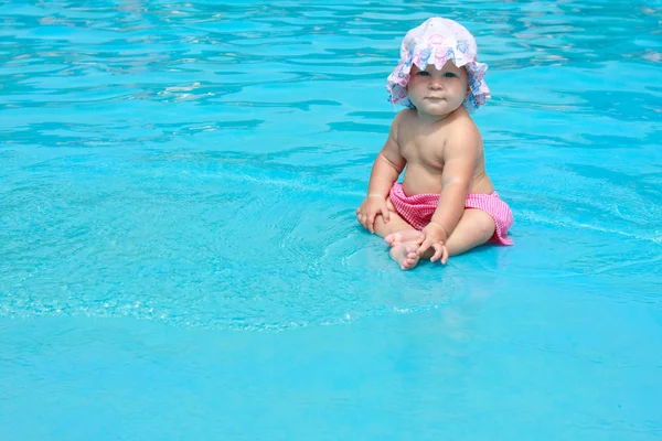 Niedliches Baby Mädchen sitzt im Pool — Stockfoto