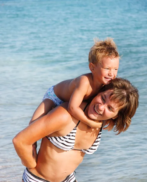 Happy mother and son playing in water — Stock Photo, Image