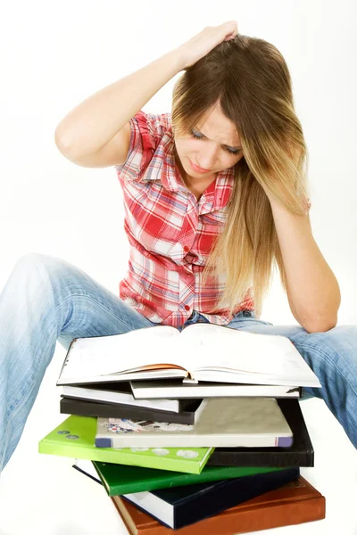 Menina estudante perplexo com pilha de livros sobre branco — Fotografia de Stock