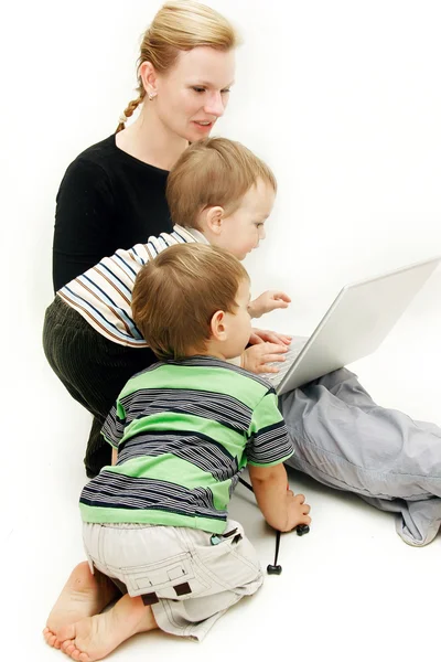 Mãe com 2 filhos e laptop sobre branco — Fotografia de Stock