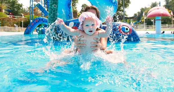 Happy baby girl with mother in waterpool — Stock Photo, Image