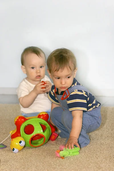 Två baby pojkar med leksaker — Stockfoto