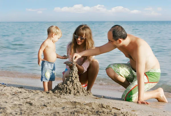 Jeune famille heureuse sur la plage — Photo