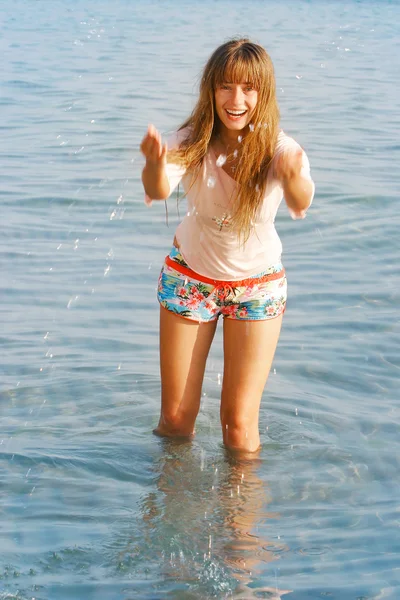 Счастливая девочка, играющая в капельки воды — стоковое фото