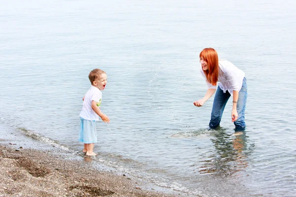 母と息子のビーチの水で遊ぶ — ストック写真