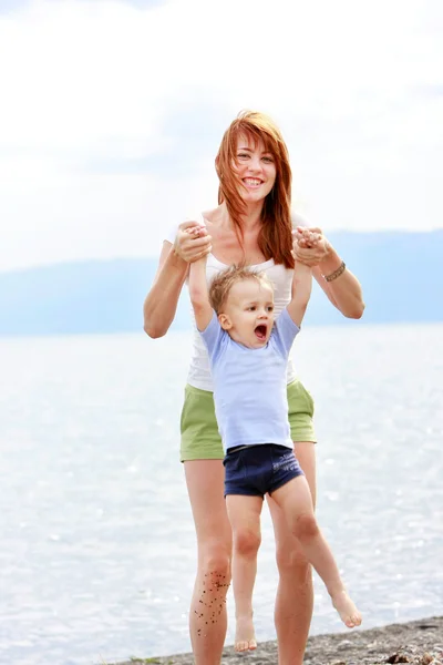 Happy matka a syn hraje na pláži — Stock fotografie