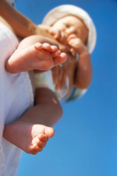 Baby on parent's hands, focus on feet — Stock Photo, Image