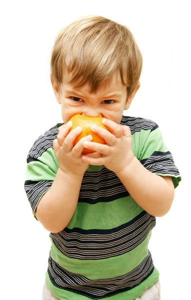 Menino comendo laranja sobre branco — Fotografia de Stock