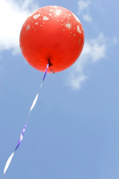 Ballon rouge avec des coeurs contre le ciel bleu — Photo
