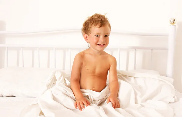 Menino feliz na cama — Fotografia de Stock