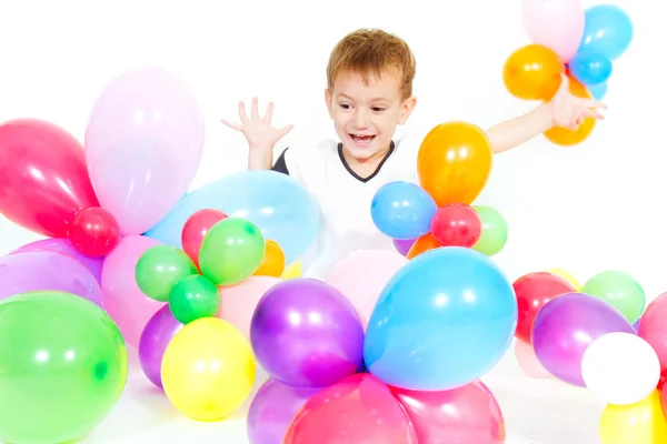 Menino bonito jogando com balões coloridos sobre branco — Fotografia de Stock