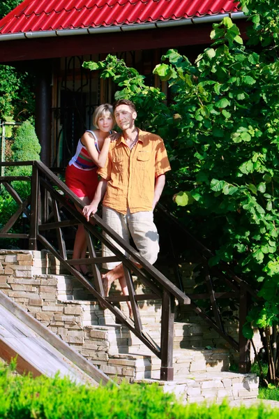 Young attractive couple on stairs of their new house — Stock Photo, Image