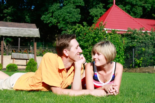 Junges Paar liegt auf Gras — Stockfoto