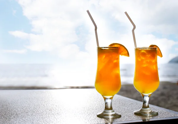 Two glasses of orange juice on sky background — Stock Photo, Image