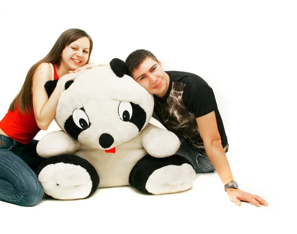 Jovem casal com grande brinquedo-panda sobre branco — Fotografia de Stock