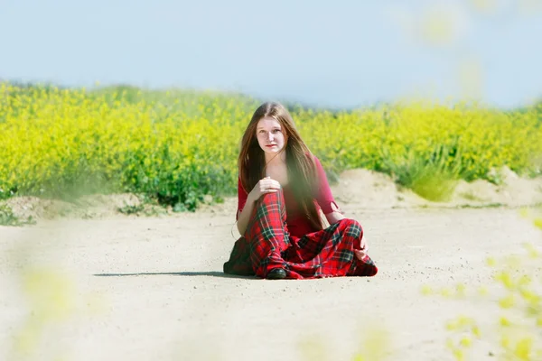 Alone teen girl sitting on rural road — Stock Photo, Image