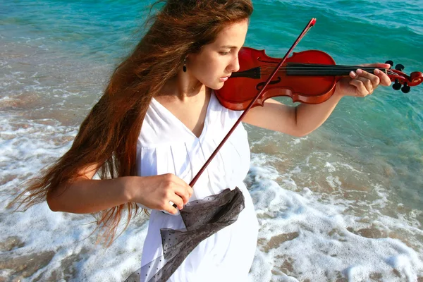 Mladá atraktivní žena hrající housle na pozadí moře — Stock fotografie