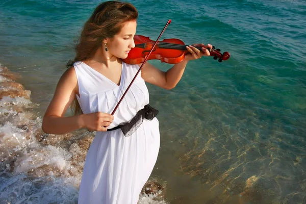 美丽的姑娘演奏小提琴的海面背景 — 图库照片