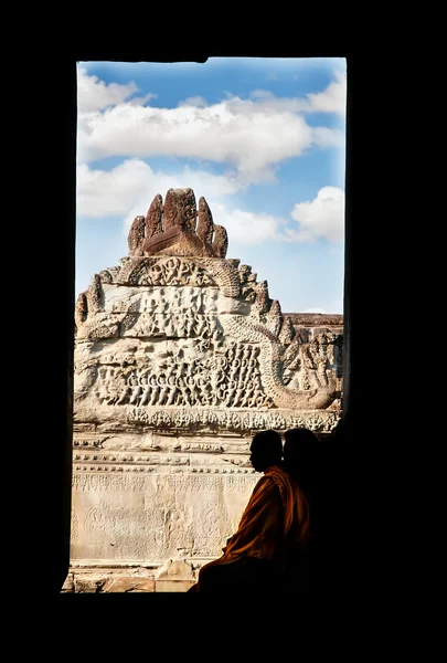 Silhouette eines Mönchs, der im Fensterrahmen auf altem Tempelhintergrund sitzt — Stockfoto