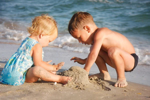 Two kids playing on beach — Stock Photo, Image