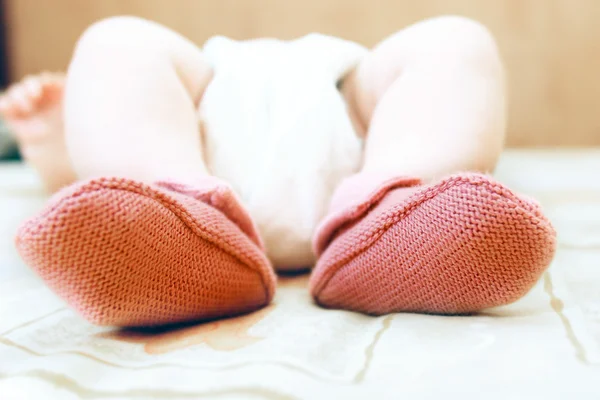 Närbild på barnets fötter i rosa strumpor — Stockfoto