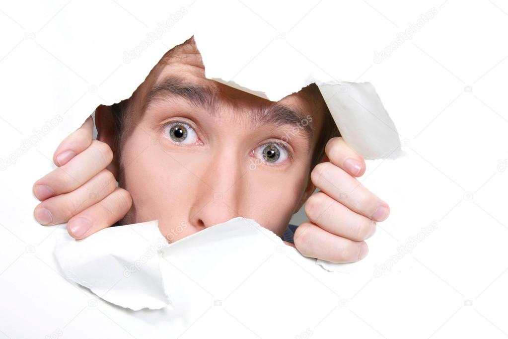 young man peeping through hole on paper