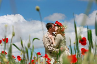 Kırmızı poppies sahada seven genç Çift