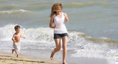 mutlu anne ve oğul plaj üzerinde çalışan