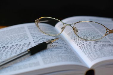 kalem ve kitap sayfası gözlük
