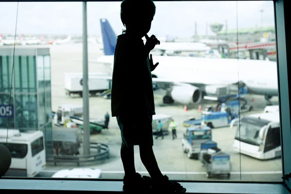 Silueta mladého chlapce na letišti pozadí okna — Stock fotografie