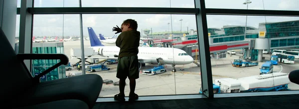 Unavený chlapec na letišti pozadí okna — Stock fotografie