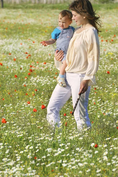 Moeder en zoon lopen door bloemen — Stockfoto