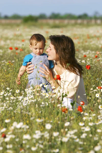 Moeder en zoon in bloemen — Stockfoto