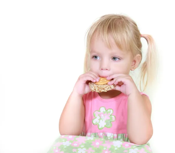 Chica joven comiendo bocadillos sobre blanco — Foto de Stock