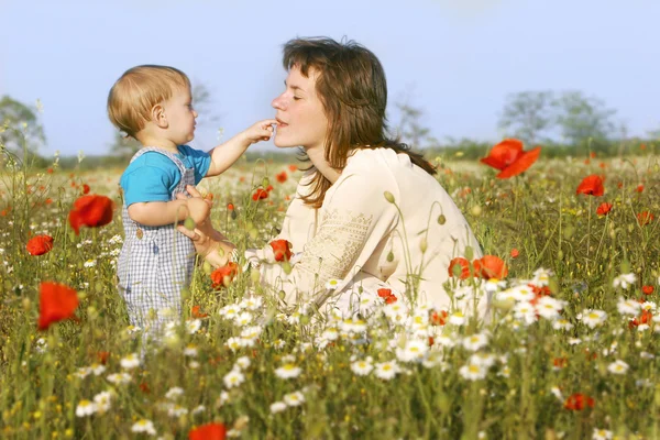 Mother and son playing in flowers — Stock Photo, Image
