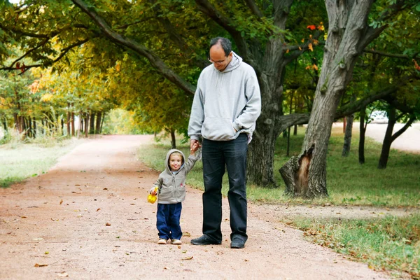 Far och son i höst park — Stockfoto