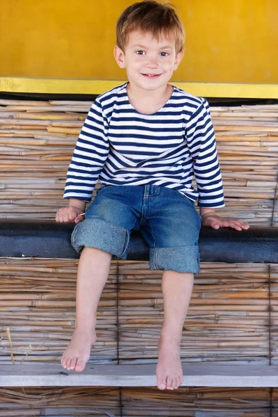 Happy young boy sitting in beach bar — Stock Photo, Image