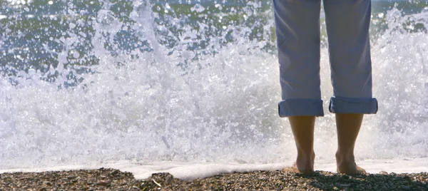 Close up van vrouwelijke voeten op kiezelstrand — Stockfoto