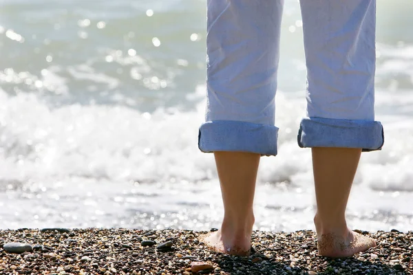 海の背景に女性の足 — Stockfoto