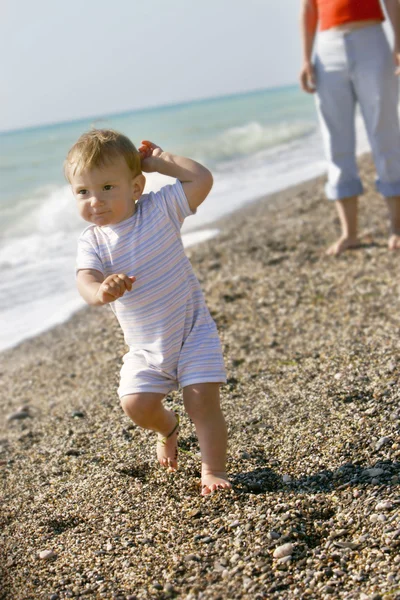 Baby going away from mother on beach — Stock Photo, Image