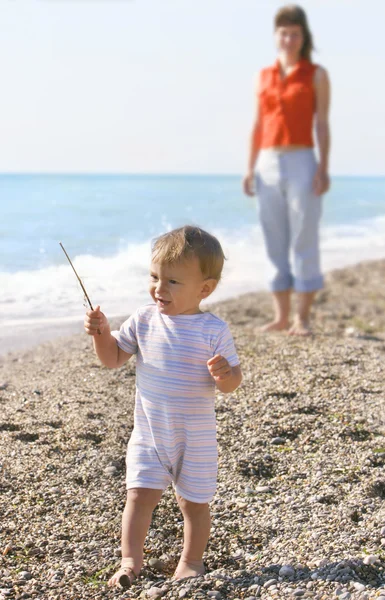 Bambino e madre sulla spiaggia di ghiaia — Foto Stock