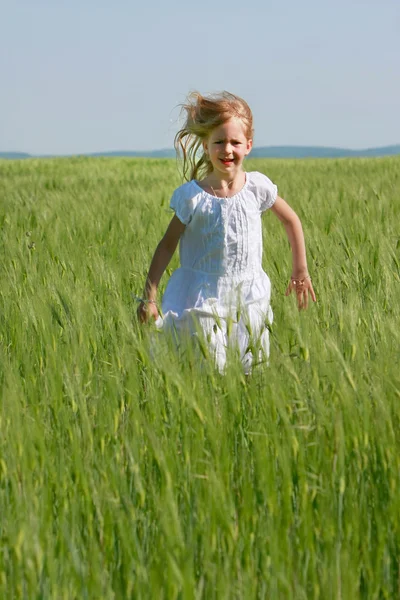 Fille mignonne courir dans l'herbe verte — Photo