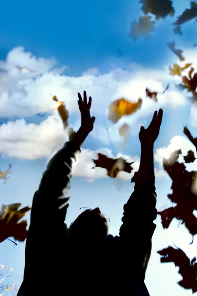 Mann wirft Laub in Herbstpark — Stockfoto