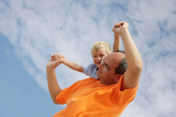 Lycklig far och son på himmel bakgrund — Stockfoto