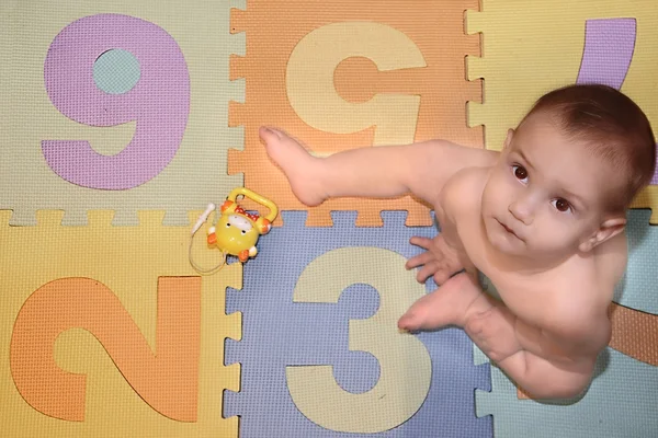 Bebé sentado en el fondo con números — Foto de Stock