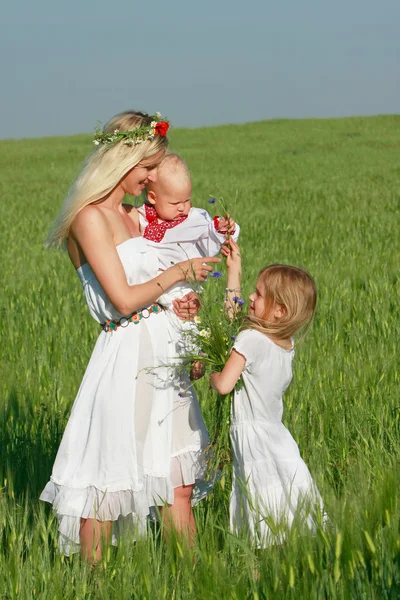 Happy mother with two children in traditional clothes outdoors — Stock Photo, Image