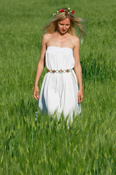 Jovem menina bonita andando no campo verde — Fotografia de Stock